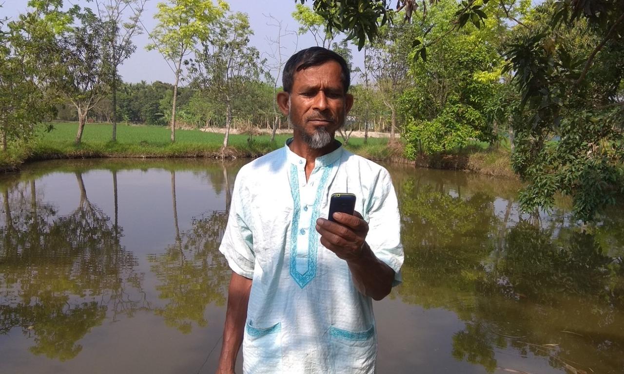 A fish farmer from Rangpur receiving weather forecast from Bangladesh Meteorological Department’s toll-free hot line number. Photo by Harun Or Rashid